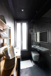 uma casa de banho preta com um lavatório e um WC em Le splendide (Chic & Chaleureux) em Vincennes