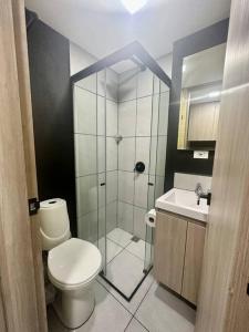 ein Bad mit einer Dusche, einem WC und einem Waschbecken in der Unterkunft Loft Belmont Suites (203) in Pereira