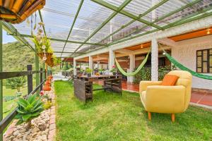 an outdoor patio with a pergola and a chair at Cabaña Tipo Glamping Savieza Life Experience in Nemocón