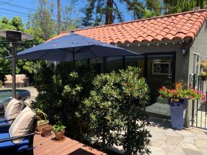 Casita LA في لوس أنجلوس: منزل فيه مظله زرقاء وبعض النباتات