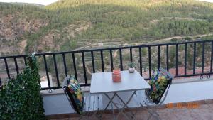 d'une table et de chaises blanches sur un balcon avec vue. dans l'établissement Casa Nieves -La buardilla del cielo, à Villahermosa del Río