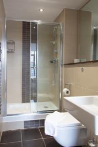 a bathroom with a shower and a toilet and a sink at Central Gem: Cosy 2BR with Private Balcony in Manchester