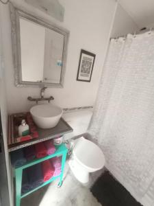 y baño con lavabo, aseo y espejo. en Casa del Angel Duplex Centrico con Patio en La Plata