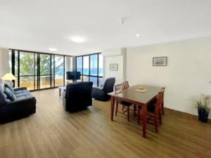 a living room with a table and a couch at Pacific Towers Beach Resort in Coffs Harbour