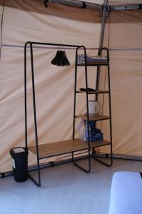 ein Regal in einem Zelt mit Besen in der Unterkunft Regan Luxcamp by Digihub Hospitality in Palayangan