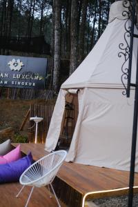 a white tent with a table and a chair at Regan Luxcamp by Digihub Hospitality in Palayangan