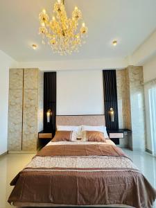 a bedroom with a large bed and a chandelier at Grand Sri Lounge - Ocean Breeze Hotel residents in Negombo