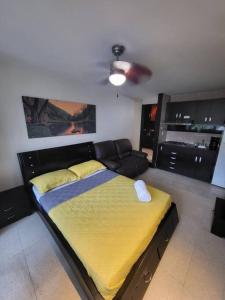 een slaapkamer met een bed en een bank erin bij R.1102 Lindo estudio ejecutivo en área turística. in Panama-Stad