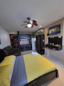 een slaapkamer met een bed en een plafondventilator bij R.1102 Lindo estudio ejecutivo en área turística. in Panama-Stad