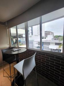 een kamer met een tafel, stoelen en ramen bij R.1102 Lindo estudio ejecutivo en área turística. in Panama-Stad