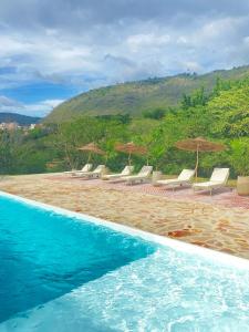 una piscina con sillas y sombrillas en una playa en Trip Monkey del Río, en San Gil