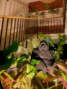 una estatua de un mono sentado en algunas plantas en Trip Monkey del Río, en San Gil