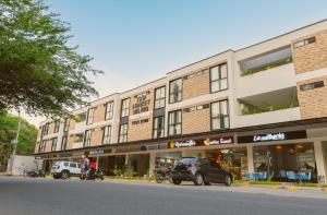 ein großes Gebäude, vor dem Autos parken in der Unterkunft Trip Monkey del Río in San Gil