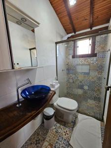 a bathroom with a toilet and a sink and a shower at Chalés Vila Real - Tranquilidade na Serra de Carrancas - Piscina com uma vista espetacular do Pôr do Sol in Carrancas