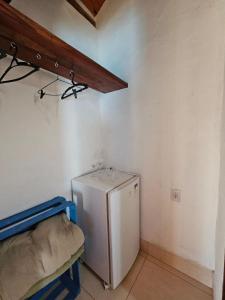 a kitchen with a refrigerator and a chair in a room at Chalés Vila Real - Tranquilidade na Serra de Carrancas - Piscina com uma vista espetacular do Pôr do Sol in Carrancas
