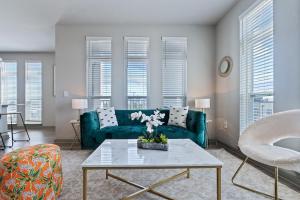 a living room with a green couch and a table at Central Avenue 2 Bed Mins From Tropicana Field in St Petersburg