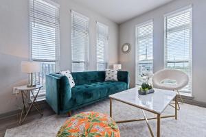 a green couch in a living room with windows at Central Avenue 2 Bed Mins From Tropicana Field in St Petersburg