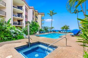 a swimming pool in front of a building with a resort at Hono Koa Vacation Club in Lahaina
