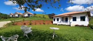 a yard with chairs in front of a house at Quinta dos Faisões in Santo Antônio do Pinhal +92 photos