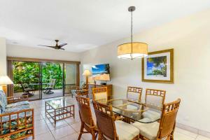 a dining room and living room with a table and chairs at Hono Koa Vacation Club in Lahaina