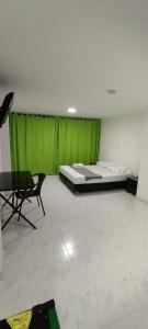 a room with a bed and a green curtain at HOTEL PROVENZA MEDELLIN in Medellín