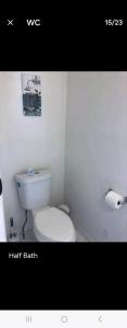 a bathroom with a white toilet and a roll of toilet paper at LOVELY RENOVATED 2 BEDROOM HOME WITH FREE Parking in Albany