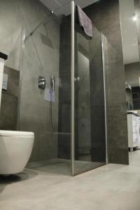 a shower with a glass door in a bathroom at Channel Centrum Deptak PKP PKS -zameldowanie -wymeldowanie bez kontaktowe in Kielce +20 photos