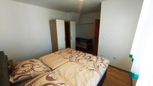 a small bedroom with a bed in a room at Holiday House Križanović in Sikirevci