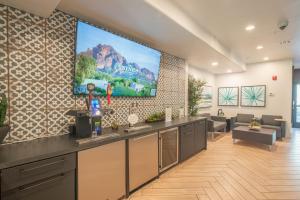 a room with a large tv on the wall at Exclusive Unit-Walkable Area-Bright & Sunny 2 BR - N272 in Scottsdale