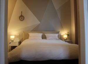 a bedroom with a large white bed with two lamps at La Rondine in Gravedona