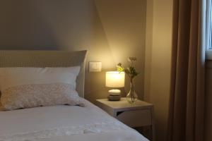 a bedroom with a bed with a lamp on a night stand at La Rondine in Gravedona