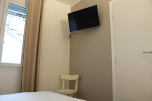 Habitación con cama y TV en la pared. en La Rondine, en Gravedona