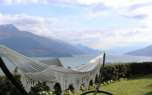 a hammock with a view of the water and mountains at La Rondine in Gravedona