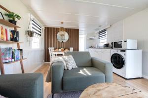 a living room with a chair and a microwave at 64, Charming Nature Retreat, Near Efteling, with Private Parking & Garden in Oisterwijk +31 photos
