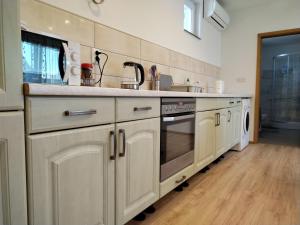 a kitchen with a sink and a stove at Holiday House Križanović in Sikirevci