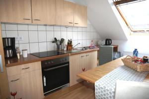 een keuken met houten kasten en een zwarte vaatwasser bij Nadines Ferienwohnung in Krefeld