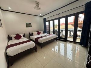 1 Schlafzimmer mit 2 Betten und einem großen Fenster in der Unterkunft Central Mountain View Hotel in Vang Vieng