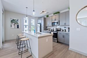 a kitchen with white cabinets and a large island with bar stools at Downtown Saint Pete 2 Bed Near Tropicana Field in St Petersburg