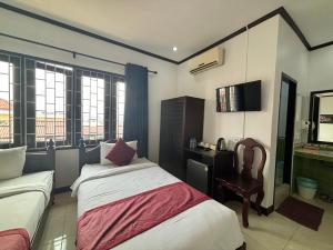 ein Hotelzimmer mit 2 Betten und einem Stuhl in der Unterkunft Central Mountain View Hotel in Vang Vieng