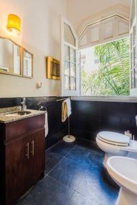 een badkamer met een toilet, een wastafel en een raam bij Sky Garden Sarandi [ Decó ] Pool & Barbacue in Montevideo
