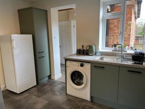 uma cozinha com uma máquina de lavar roupa e um lavatório em Large 7 double bedroom house with large driveway em Earlham