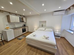 um quarto com uma grande cama branca e uma cozinha em Apartment Zakrjan in Old town Korčula em Korčula