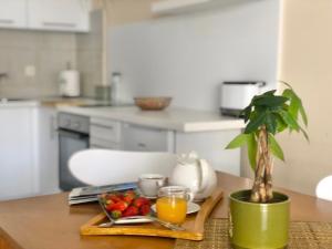 a table with a plate of fruit and a potted plant at Apartments Lungo Mare Ulcinj in Ulcinj