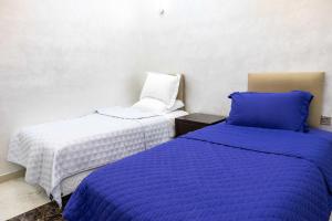 een slaapkamer met 2 bedden en een stoel bij Andalusia farm in Al Rahba