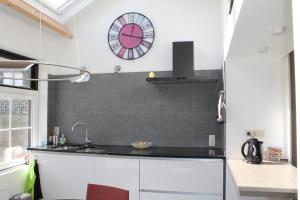 eine Küche mit einer großen Uhr an der Wand in der Unterkunft Huisje Zeertevree in Nieuwvliet