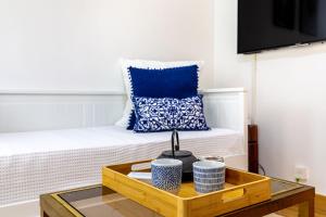 een kamer met een bed met een blauw kussen en een salontafel bij Maison élégante 15 minutes de paris in Arcueil