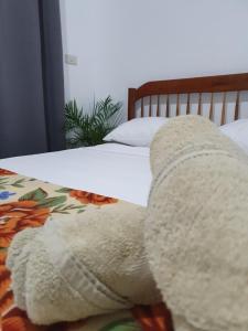 a large white teddy bear laying on a bed at Maui Homestay in General Luna