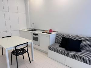 eine Küche mit einem Sofa, einem Tisch und einem Waschbecken in der Unterkunft Duomo intero appartamento in Mailand