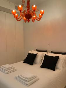 Schlafzimmer mit einem Bett mit weißer Bettwäsche und einem Kronleuchter in der Unterkunft Duomo intero appartamento in Mailand