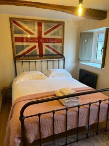 una camera da letto con un letto con una bandiera sul muro di The Old Forge a Cheltenham